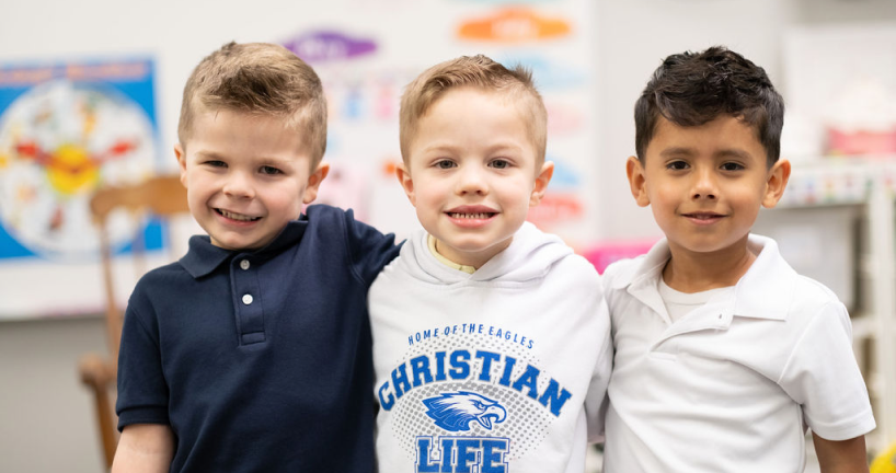 Three boys standing with their arms around eachother