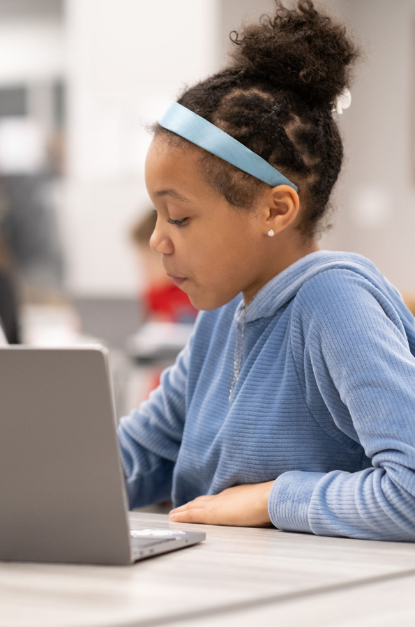 Young girl studying on laptop