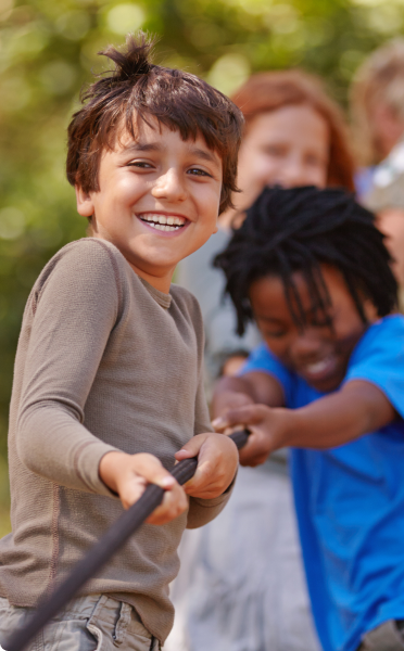 Kids laughing and pulling a rope