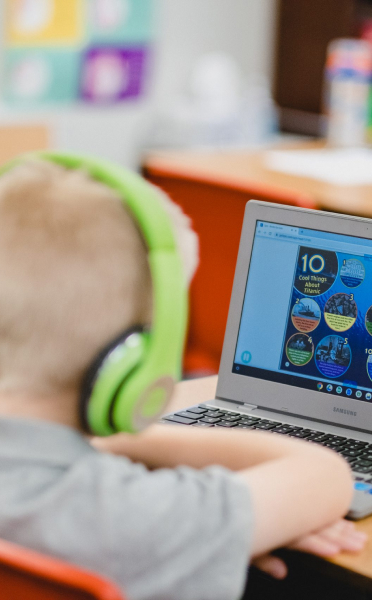 Student with headphones learning on computer